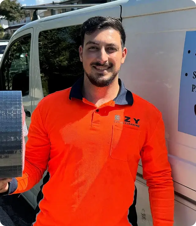 EZY Solar Cleaning team member holding bird proofing mesh in front of a service vehicle